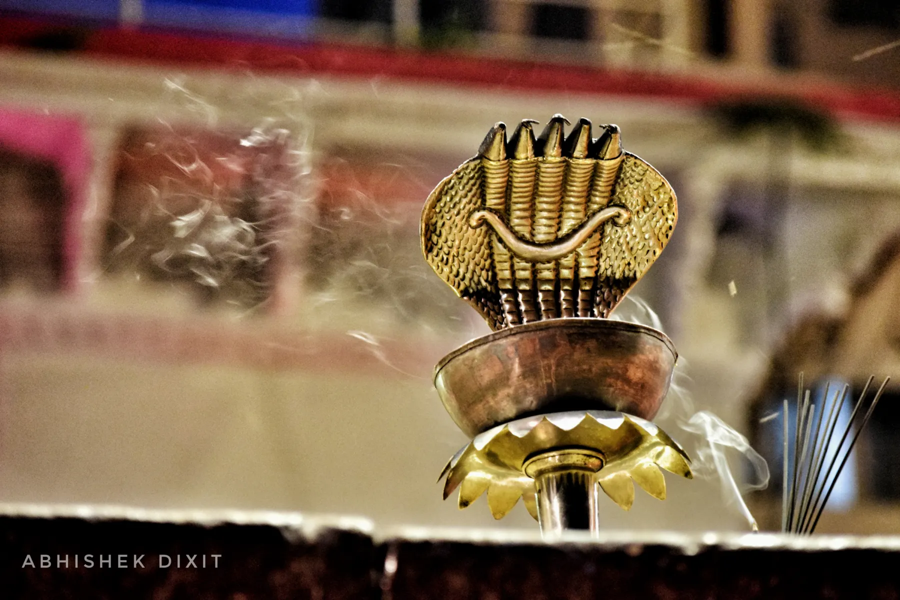 A brass serpent-hood aarti lamp in close-up