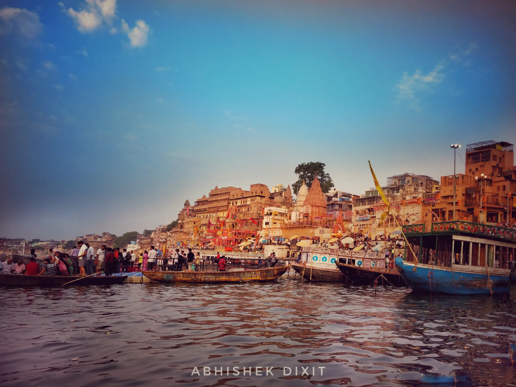 The ghats glowing in early morning sun, seen from the river