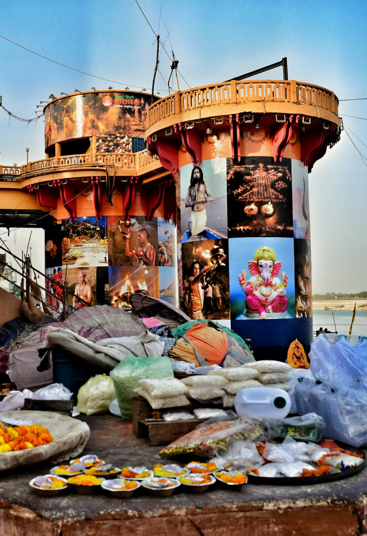 Flowers, diyas and offerings laid out at a ghat-side stall